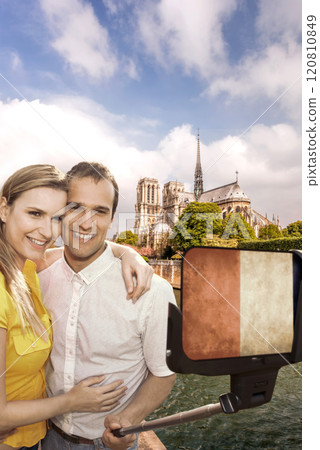 Happy couple of tourists taking selfie photo with cellphone covered a French flag in front of Notre Dame in Paris, France Happy couple of tourists taking selfie photo with cellphone covered a French flag in front of Notre Dame in Paris, France 120810849