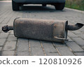 the rusty exhaust pipe, the car's muffler has fallen off and is lying on the road 120810926