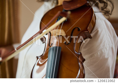 Close-up of a violin being played by a skilled musician indoors Close-up of a violin being played by a skilled musician indoors 120811002