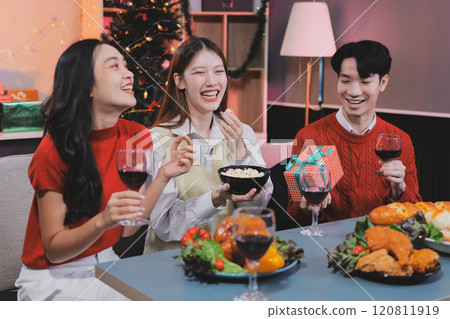 Friends opening Christmas gifts in living room Friends opening Christmas gifts in living room 120811919