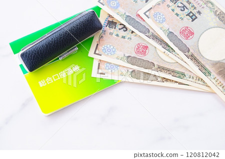 A bankbook, a seal, and a 10,000 yen note on a table 120812042