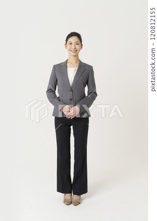 Full-body portrait of a young woman in a suit against a white background, vertical position 120812155