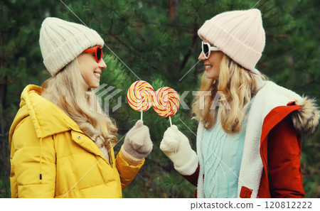 Happy smiling women friends, having fun, celebration on Christmas tree background in winter forest Happy smiling women friends, having fun, celebration on Christmas tree background in winter forest 120812222
