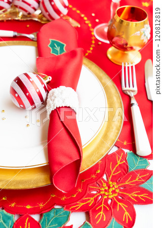 An Elegant and Beautiful Christmas Table Setting Complete with Ornamental Decorations and Fine Cutlery for Dinner 120812819