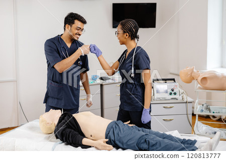 Doctors analyzing medical dummy in hospital setting Doctors analyzing medical dummy in hospital setting 120813777