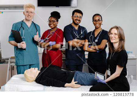 Group of doctors standing at the bed with mannequin at first aid training course 120813778