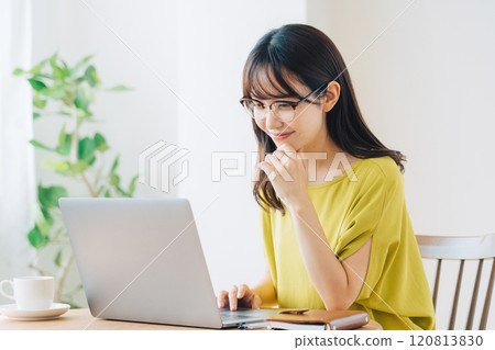 A woman using a personal computer at home A woman using a personal computer at home 120813830