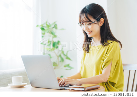 A woman using a personal computer at home A woman using a personal computer at home 120813831