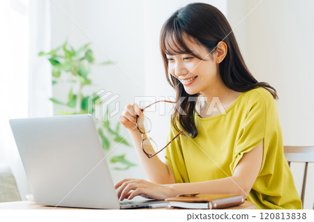 A woman using a personal computer at home 120813838
