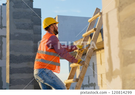 Construction worker inspecting building on ladder at sunset Construction worker inspecting building on ladder at sunset 120814299