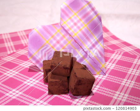 Chocolate and origami placed on pink gingham check Chocolate and origami placed on pink gingham check 120814903
