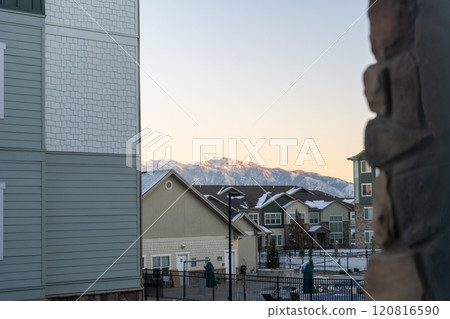 Sunlit Mountain Peaks Framed by an Apartment Complex in Salt Lake City at Sunset 120816590