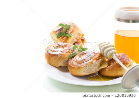 Baked goods. Sweet buns with cottage cheese filling and honey in a plate isolated on a white background 120816936