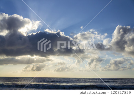 Breathtaking sunrise with sun hiding behind cloud, sea waves and blue sky with copy space 120817839
