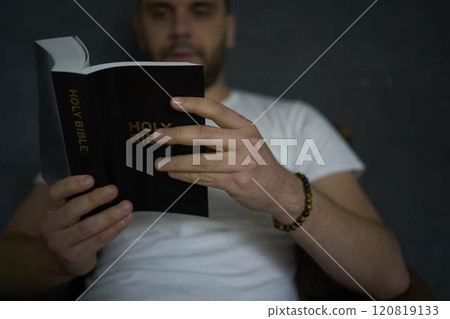 A 30-year-old man with a Bible attends an online church service, talks with the pastor A 30-year-old man with a Bible attends an online church service, talks with the pastor 120819133