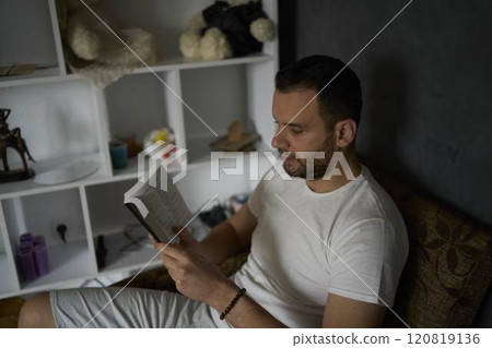 A 30-year-old man with a Bible attends an online church service, talks with the pastor 120819136