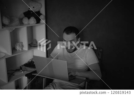 A 30-year-old man is stressed while working on a laptop from his home office 120819143