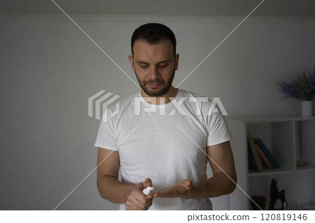 A 30-year-old man applies foam for washing on his skin 120819146