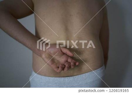 a pain in the back, lower back of a 30-year-old man 120819165