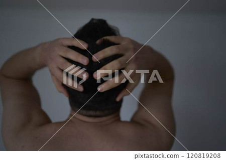 30-year-old man is stressed, holding his head with his hands 120819208