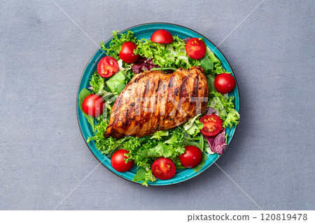 Grilled chicken breast ( fillet ) with lattuce salad and cherry tomatoes . Top view Grilled chicken breast ( fillet ) with lattuce salad and cherry tomatoes . Top view 120819478