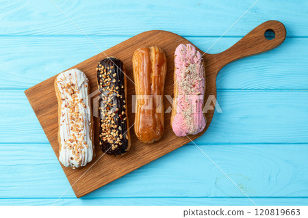 Assorted eclairs on a pastel top view Traditional French dessert 120819663