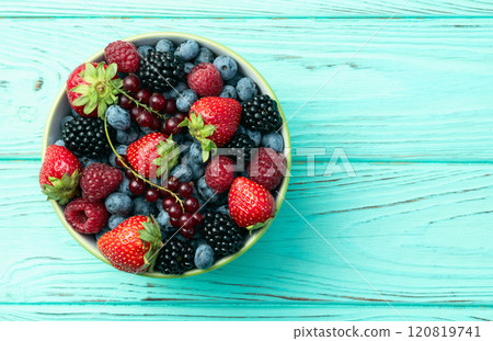 Mix of ripe colorful berries in bowl photography . Blueberry , strawberry , raspberry , blackberry and red currant . Top view 120819741