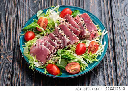 Salad with raw tuna , sesame and cherry tomatoes photography . Top view 120819840