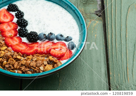 Healthy breakfast . Yogurt with berries ( strawberry , raspberry , blueberry , blackberry ) , granola and chia seeds . Top view Healthy breakfast . Yogurt with berries ( strawberry , raspberry , blueberry , blackberry ) , granola and chia seeds . Top view 120819859