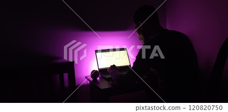 Young man silhouette sitting computer laptop in studio on violet background Young man silhouette sitting computer laptop in studio on violet background 120820750