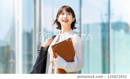 走在辦公區的一位微笑的女商人 走在辦公區的一位微笑的女商人 120821642