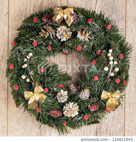 Christmas Wreath made of pine branches, cones, golden bows, red berries, silver twigs on a wooden table. New Year's home wall decor different angles handmade top view Christmas Wreath made of pine branches, cones, golden bows, red berries, silver twigs on a wooden table. New Year's home wall decor different angles handmade top view 120821943
