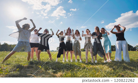 School friends dancing in a meadow on a summer afternoon. School friends dancing in a meadow on a summer afternoon. 120822262