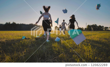 School children run and toss their notebooks up at sunset. School children run and toss their notebooks up at sunset. 120822269