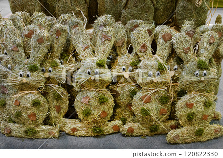 Easter decorative bunnies made from hay stand in rows, ready for sale. Handmade. 120822330