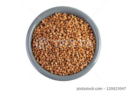 Raw buckwheat in ceramic bowl isolated on white background. Top view. Flat lay 120823047
