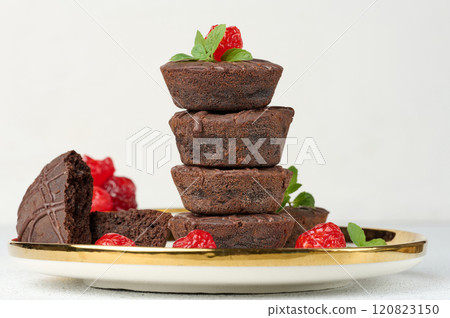 Chocolate brownies stacked with the top adorned by a red juicy cherry and mint leaves 120823150