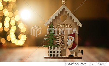 hanging X Mas decoration on blurred Christmas tree hanging X Mas decoration on blurred Christmas tree 120823706