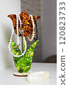 A flowershaped holder organizes necklaces and rings on a table 120823733