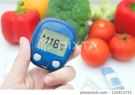 Person is holding a blood glucose meter Person is holding a blood glucose meter 120823741
