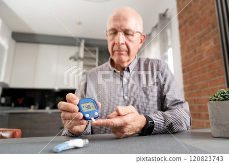 Man is taking his blood sugar reading 120823743