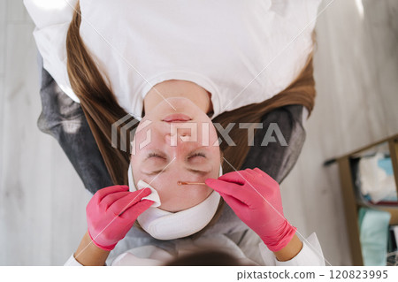 Top view of skincare professional performs a deep pore cleansing treatment, using a gentle tool to purify and clear the client's skin 120823995