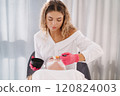 Skincare specialist distributes the clay mask thoroughly over the client's face, ensuring even coverage for a balanced complexion 120824003