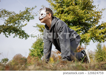 Portrait of a boy quadrober in a mask on a blue sky background, teenage problems Portrait of a boy quadrober in a mask on a blue sky background, teenage problems 120824759