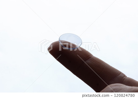 Contact lenses for vision correction. A woman holds a contact lens on her finger, close-up. macro Contact lenses for vision correction. A woman holds a contact lens on her finger, close-up. macro 120824780