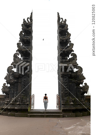 A woman stands at the Balinese traditional gate in the clouds at the sacred temple of Pura Pasar Agung Sebudi on Mount Agung. A woman stands at the Balinese traditional gate in the clouds at the sacred temple of Pura Pasar Agung Sebudi on Mount Agung. 120825003