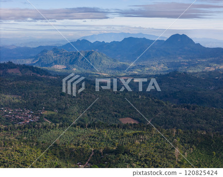 Lush green hills and mountains under bright blue sky in remote area 120825424