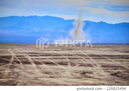 Dust Devil in Arid Desert with Mountain Backdrop Eye Level Perspective 120825494