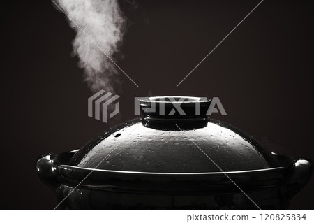 Image of hot pot cooking with steam rising from the clay pot Image of hot pot cooking with steam rising from the clay pot 120825834