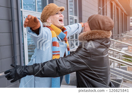 Happy elderly couple embracing outdoors in winter clothes 120825841